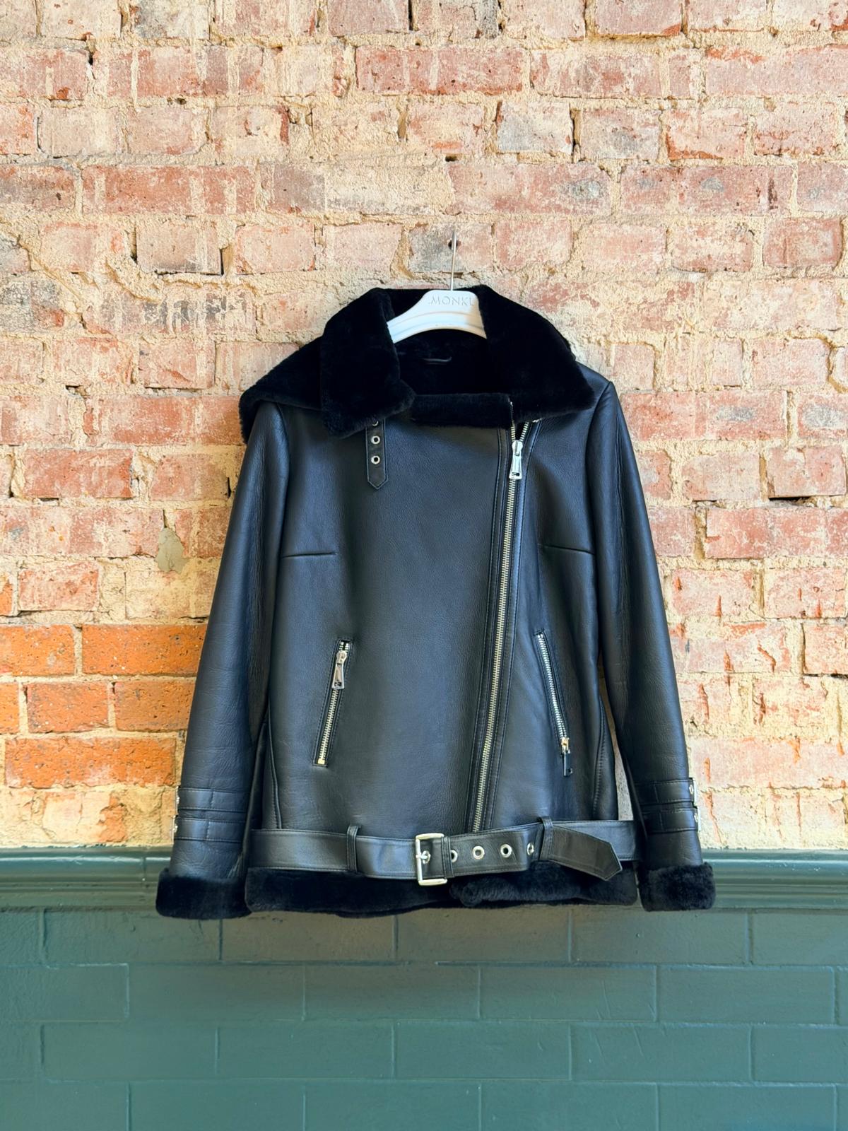 Front of black hooded women’s sheepskin biker jacket with belt and zip pockets